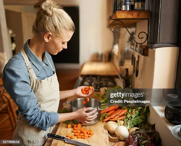 handfuls of wholesome goodness - young woman cooking in kitchen stock pictures, royalty-free photos & images