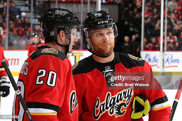 Curtis Glencross and Dennis Wideman of the Calgary Flames have a discussion during a stoppage in play against the Detroit Red Wings at Scotiabank...