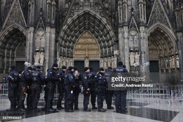 Police conduct security checks on visitors arriving for Christmas Vespers on Christmas Eve at Cologne cathedral on December 24, 2023 in Cologne,...
