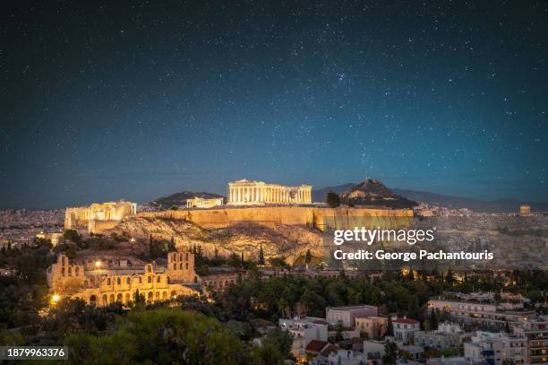 stars at night over the acropolis of athens, greece - akropolis stock-fotos und bilder