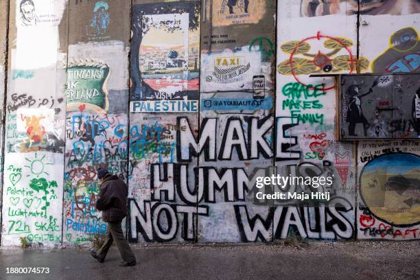 Palestinian man walks past Separation Wall on December 24, 2023 in Bethlehem, West Bank. Last month, Christian Palestinian leaders here called off...