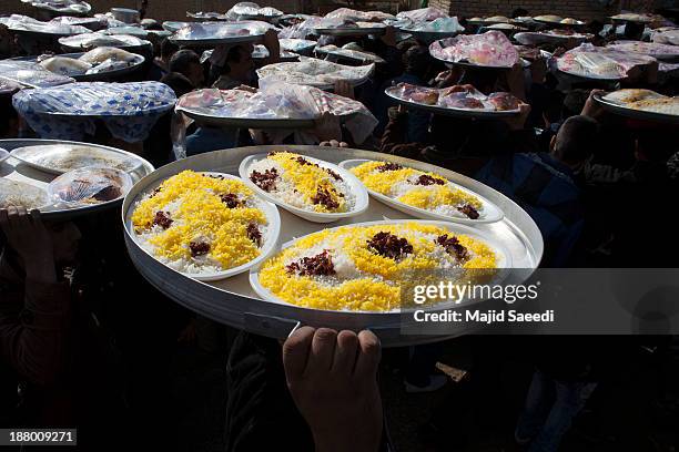 Iranians distribute food for needy people during the Ashura mourning feast November 14, 2013 in the village of Bagh Malek ,480 Km south of Tehran,...