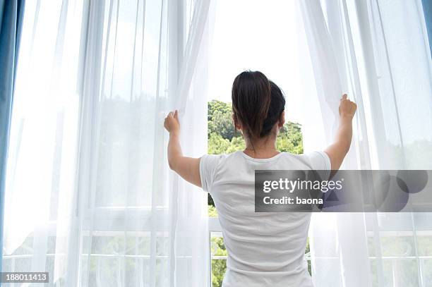 woman opening white see-through curtains - green curtain stock pictures, royalty-free photos & images