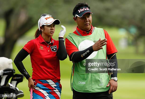 Pornanong Phatlum of Thailand chats with her caddie on the 16th hole during the first round of the Lorena Ochoa Invitational Presented by Banamex and...