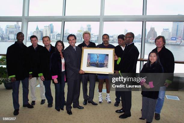 Raphael le Masne de Chermont , executive chairman of Tangs Department Stores Ltd receives a souvenir from American athletics legend Edwin Moses as...