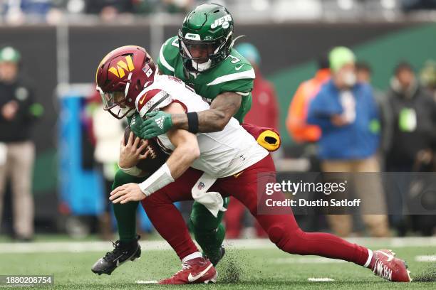 Sam Howell of the Washington Commanders is sacked by Jordan Whitehead of the New York Jets during the first quarter at MetLife Stadium on December...
