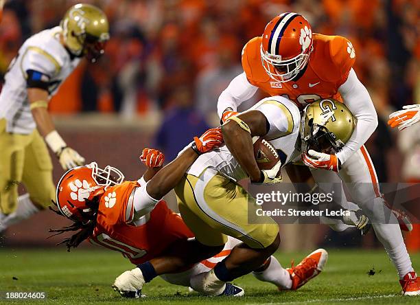 David Sims of the Georgia Tech Yellow Jackets is hit by teammates Jadar Johnson and Darrell Smith of the Clemson Tigers during their game at Clemson...