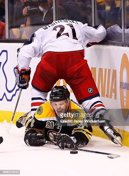 Carl Soderberg of the Boston Bruins reacher for a puck underneath the legs of James Wisniewski of the Columbus Blue Jackets in the third period...