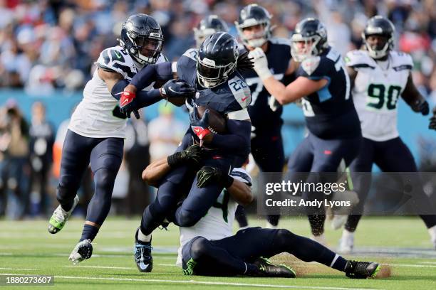 Derrick Henry of the Tennessee Titans is tackled by Bobby Wagner of the Seattle Seahawks during the first half at Nissan Stadium on December 24, 2023...