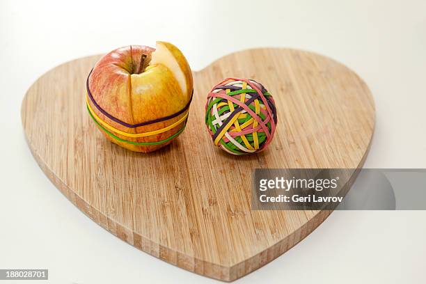 cut apple and ball of rubber bands - elastic band ball ストックフォトと画像