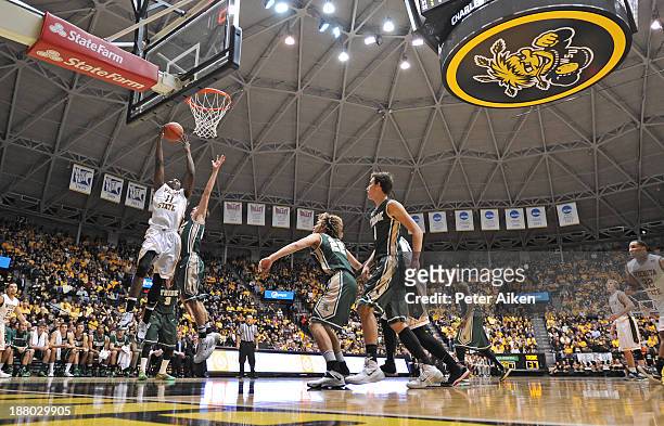 Forward Cleanthony Early of the Wichita State Shockers drives to the basket against guard Omar Prewitt of the William & Mary Tribe during the first...