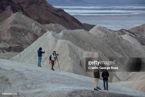 Photographers take pictures at the iconic overlook at Zabriskie Point at sunrise on December 15 near Furnace Creek, California. Death Valley National...