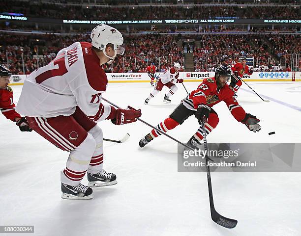 Johnny Oduya of the Chicago Blackhawks tries to catch a pass by Radim Vrbata of the Phoenix Coyotes at the United Center on November 14, 2013 in...
