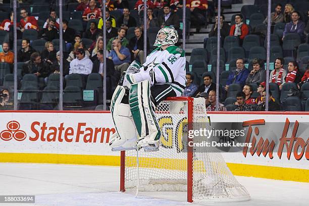Kari Lehtonen of the Dallas Stars jumps onto the top of the goal to take a seat during a break in play against the Calgary Flames during an NHL game...