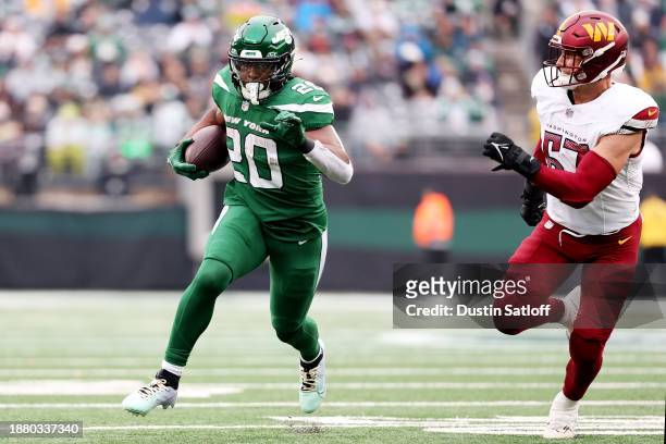 Breece Hall of the New York Jets carries the ball during the first half against the Washington Commanders at MetLife Stadium on December 24, 2023 in...