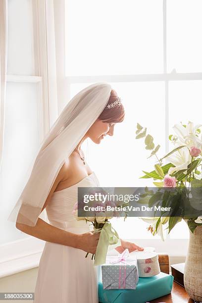 bride looks at gift. - wedding gift stock pictures, royalty-free photos & images