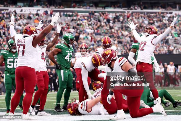 The Washington Commanders celebrate after Chris Rodriguez Jr. #23 of the Washington Commanders scores a touchdown during the second quarter against...