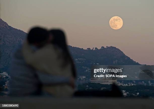 The full moon of December, known as the 'cold moon', is seen rising over the mountains as a couple kisses. The last full moon of the year and the...