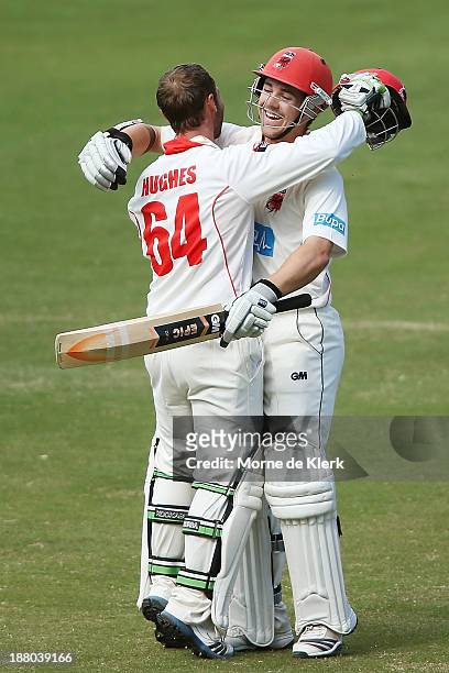 Phillip Hughes of the Redbacks is congratulated by teammate Travis Head after reaching 200 runs during day three of the Sheffield Shield match...