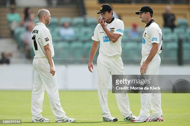 Nathan Rimmington, Nathan Coulter-Nile and Shaun Marsh of the Warriors disuss tactics during day three of the Sheffield Shield match between the...