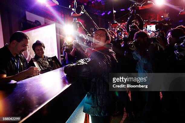 Joey Chiu center, reacts as he purchases the first Sony PlayStation 4 console during its midnight launch event in New York, U.S., on Friday, Nov. 15,...