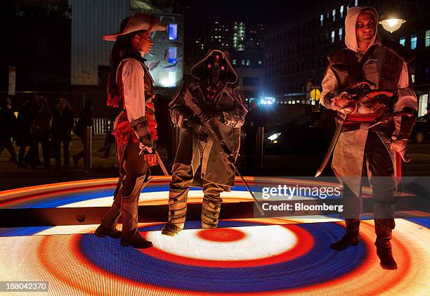 Actors dressed up as characters from the video games Kill Zone and Assassins Creed pose as fans line up to attend the Sony PlayStation 4 midnight...