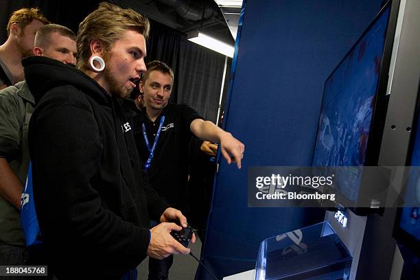 Nick Torka front, plays the video game Battlefield 4 on the Sony PlayStation 4 console during its midnight launch event in San Francisco, California,...