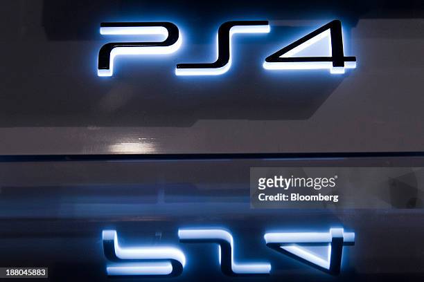 Signage for the Sony PlayStation 4 console is illuminated inside a Game Stop store during the Sony PlayStation 4 midnight launch event in San...