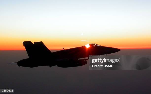 Marine F/A-18 Hornet from the VMFA-323 "Death Rattlers" squadron flies over Kuwait March 27, 2003 as it returns to the USS Constellation from a...