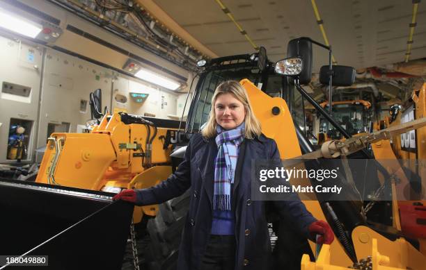 Justine Greening, Secretary of State for International Development poses for a photograph with vehicles and humanitarian aid that have been loaded...