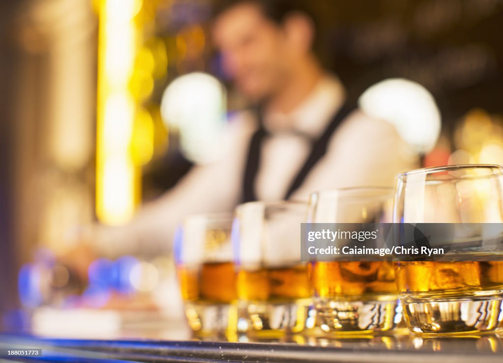 Close up of bourbon in glasses in a row on bar