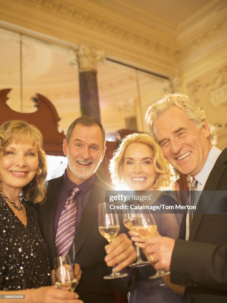 Retrato de bem vestidos amigos beber Champanhe no teatro lobby