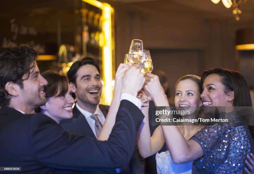 Well dressed friends toasting champagne flutes