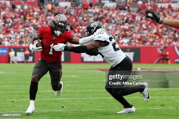 Rachaad White of the Tampa Bay Buccaneers runs the ball against Foyesade Oluokun of the Jacksonville Jaguars during the first quarter at Raymond...