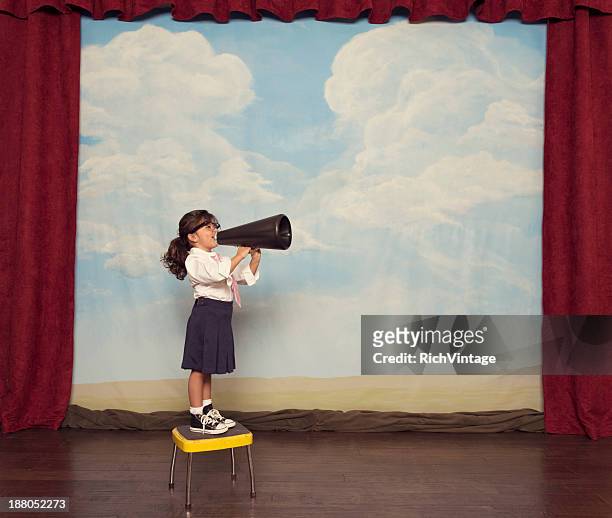young girl dressed as businesswoman yells through megaphone - kid chef stockfoto's en -beelden
