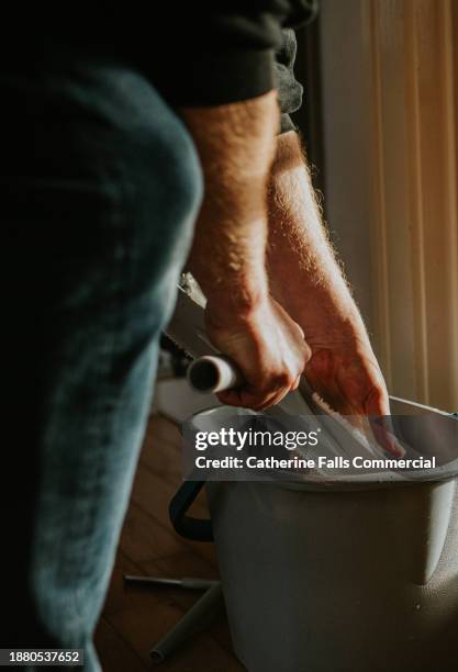 a man wrings out his squeegee into a bucket - disinfection services stock pictures, royalty-free photos & images