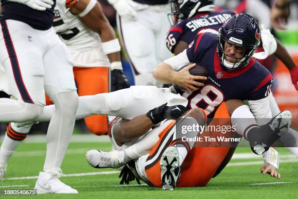 Case Keenum of the Houston Texans is sacked by Za'Darius Smith of the Cleveland Browns during the third quarter at NRG Stadium on December 24, 2023...