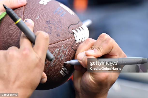 Detail view of Justin Fields of the Chicago Bears signing his autograph for fans before the game against the Arizona Cardinals at Soldier Field on...