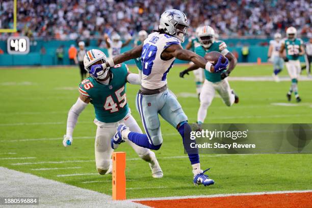 CeeDee Lamb of the Dallas Cowboys scores a touchdown while defended by Duke Riley of the Miami Dolphins during the first quarter at Hard Rock Stadium...