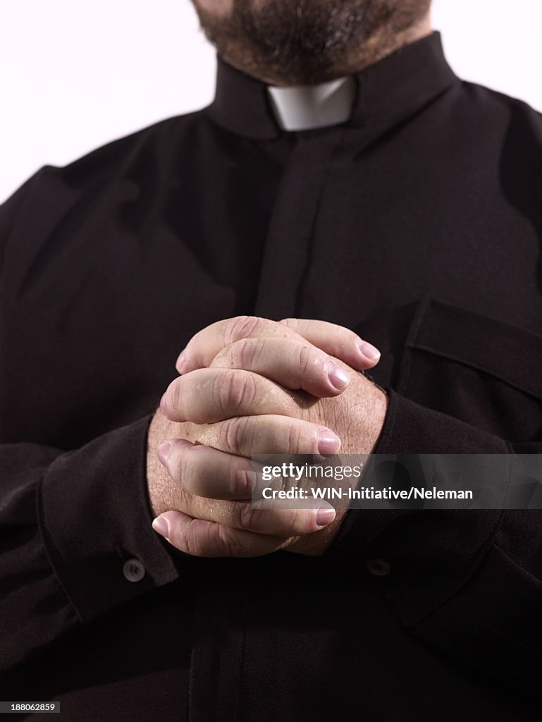 Clasped hands of a priest