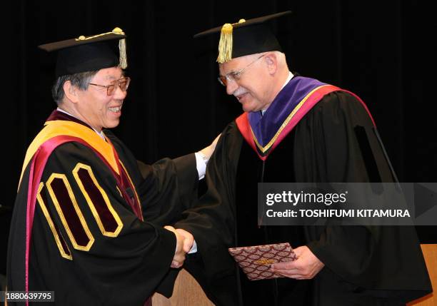 Czech President Vaclav Klaus shakes hans with Waseda University's President Katsuhiko Shirai after he received an honorary degree in Doctor of Laws...