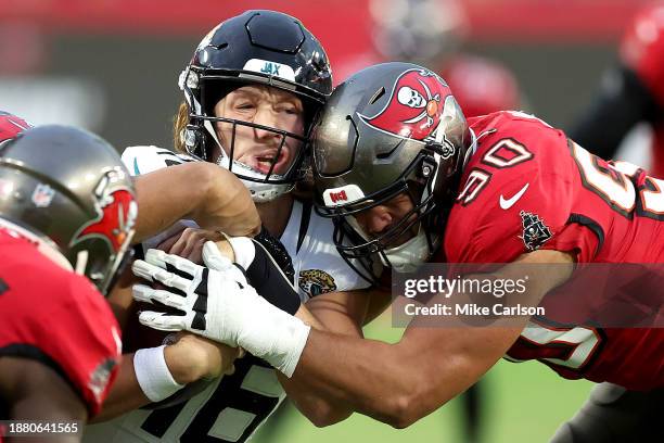 Trevor Lawrence of the Jacksonville Jaguars is hit by Logan Hall of the Tampa Bay Buccaneers during the second quarter at Raymond James Stadium on...