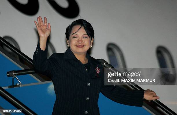 Philippines President Gloria Arroyo waves upon arriving to Hanoi international airport to attend the Asia-Pacific Economic Cooperation summit, 17...