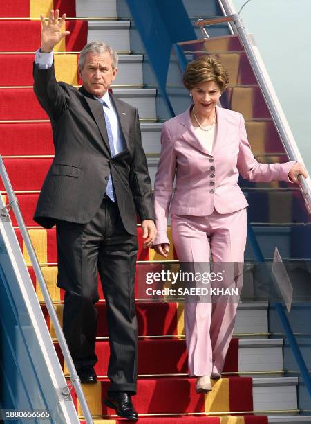 President George W.Bush and First lady Laura waves upon arriving at Hanoi international airport, 17 November 2006. President Bush arrived to attend a...