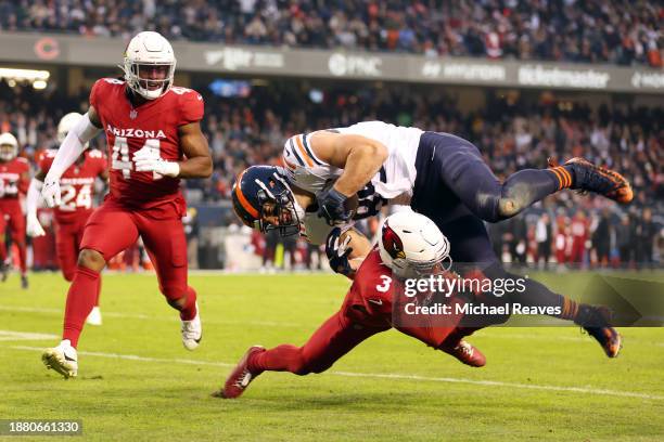 Budda Baker of the Arizona Cardinals tackles Cole Kmet of the Chicago Bears during the second quarter at Soldier Field on December 24, 2023 in...
