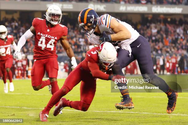 Budda Baker of the Arizona Cardinals tackles Cole Kmet of the Chicago Bears during the second quarter at Soldier Field on December 24, 2023 in...