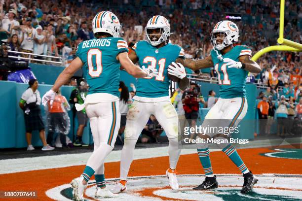 Raheem Mostert of the Miami Dolphins celebrates after a touchdown with Braxton Berrios and Cedrick Wilson Jr. #11 during the second quarter in the...