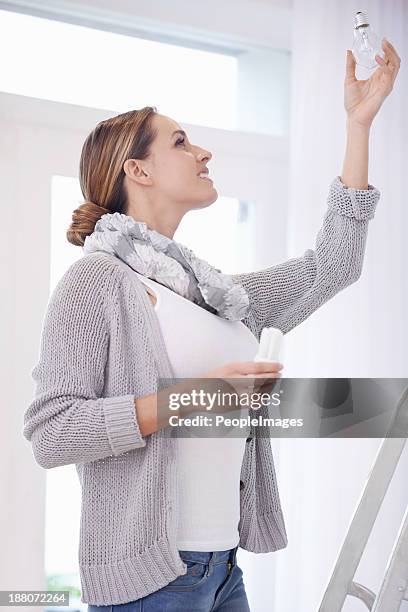 she's pretty handy around the house - lampje-vervangen stockfoto's en -beelden
