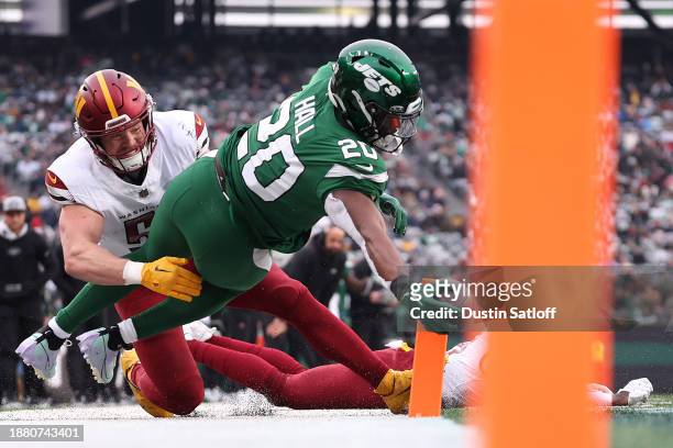 Breece Hall of the New York Jets dives for a touchdown against David Mayo of the Washington Commanders during the second quarter at MetLife Stadium...