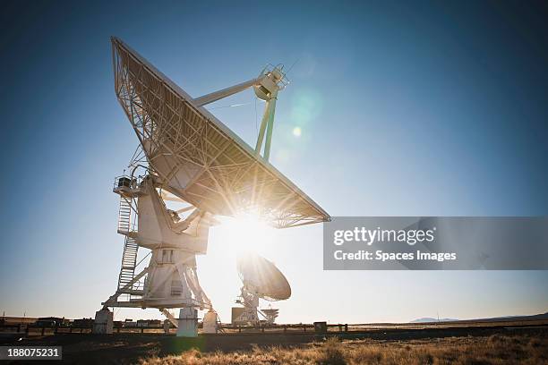 sun shining behind satellite dish in desert, socorro, new mexico, united states - satellite dish stockfoto's en -beelden